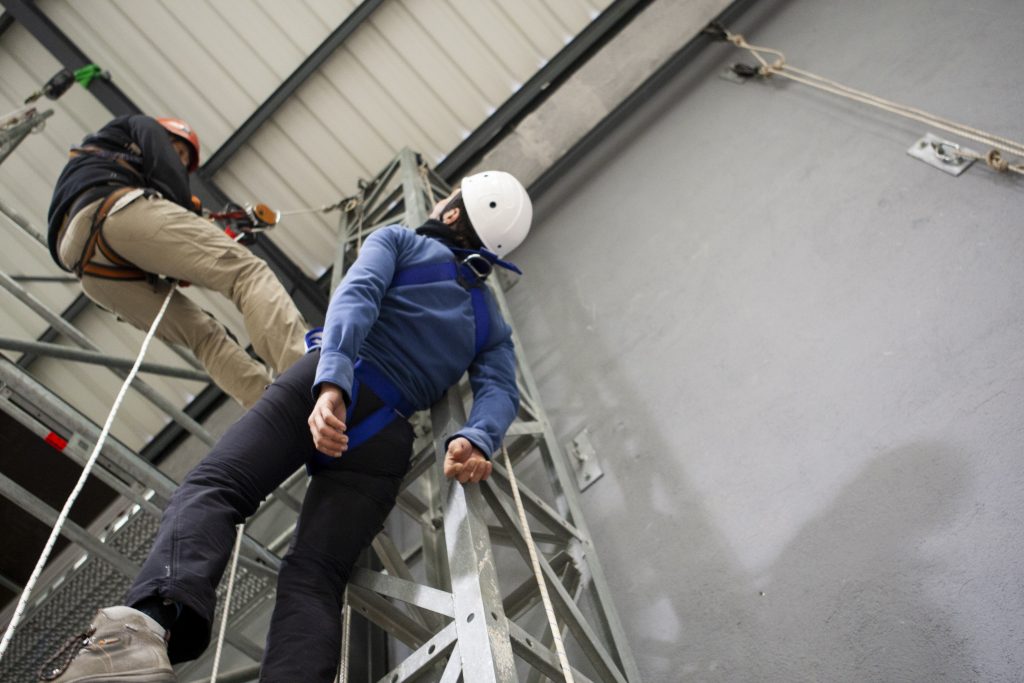 Formador enseñando rescate industrial de trabajadores verticales.