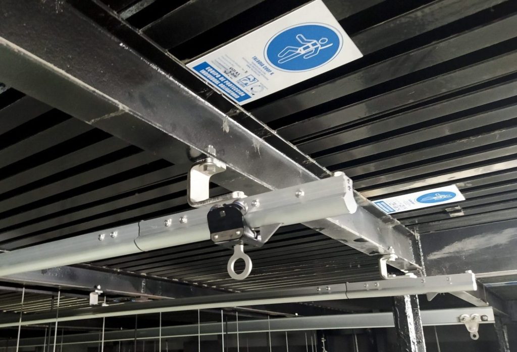Raíl de línea de vida EN 795 D instalado en techo de nave industrial